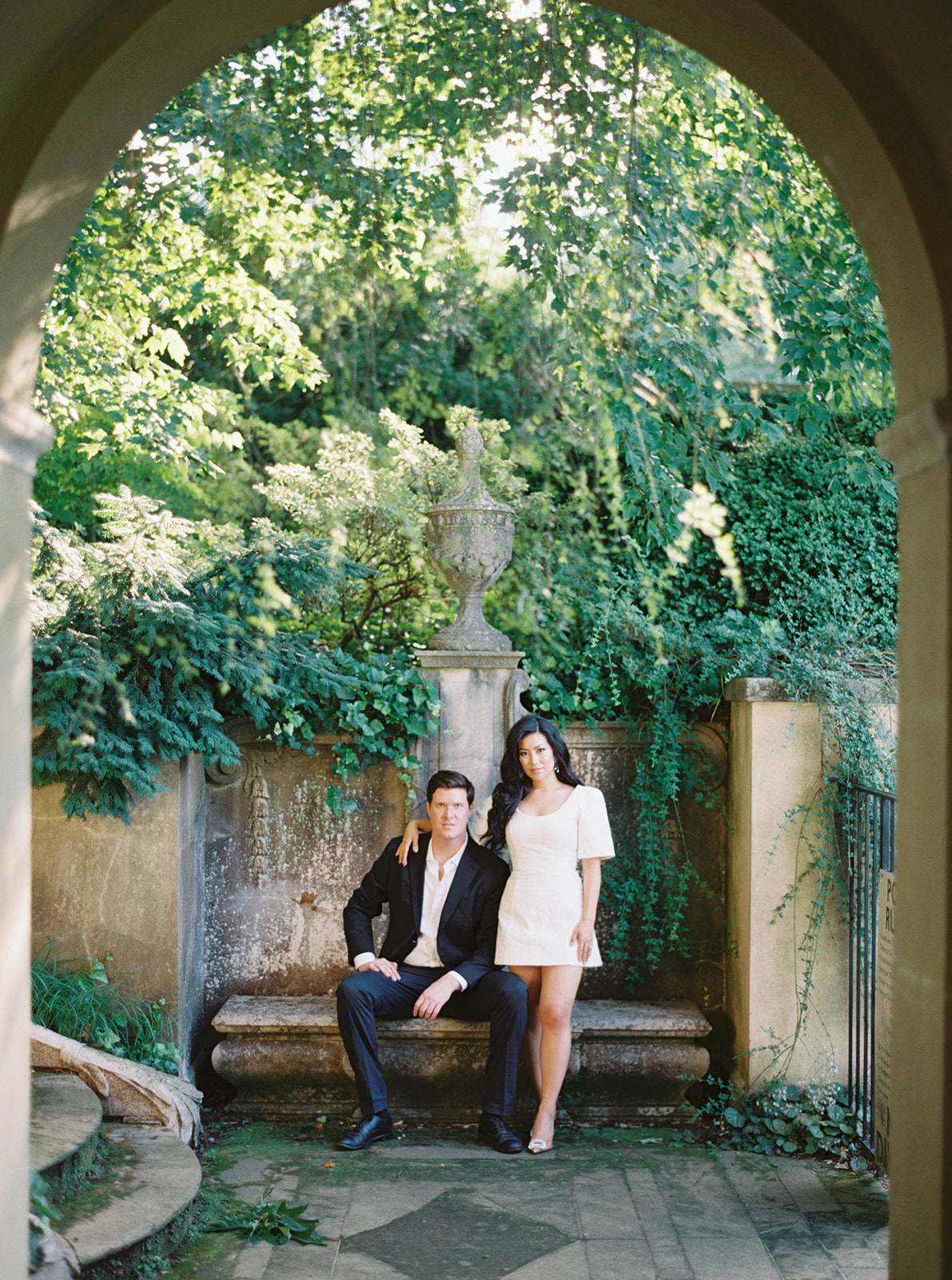 A couple poses for their engagement session in a garden.