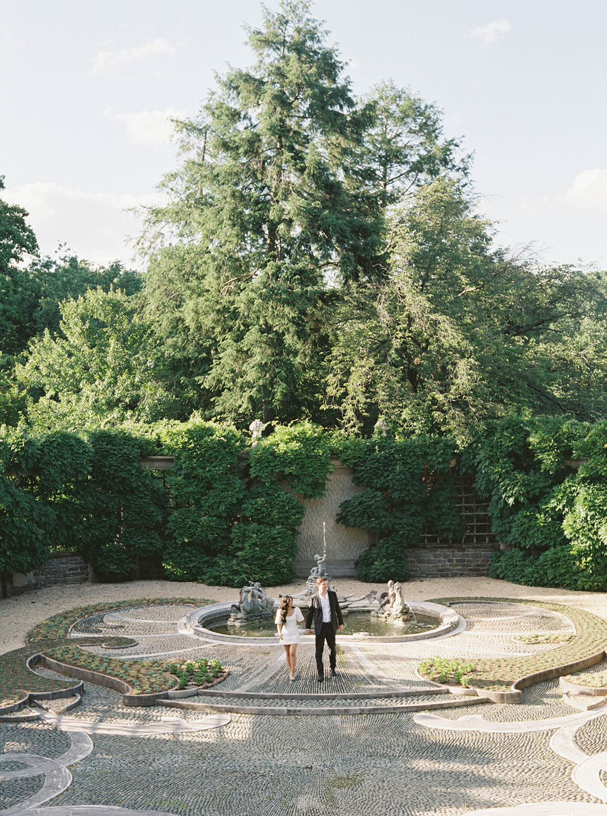 A couple poses for their engagement session in a garden.