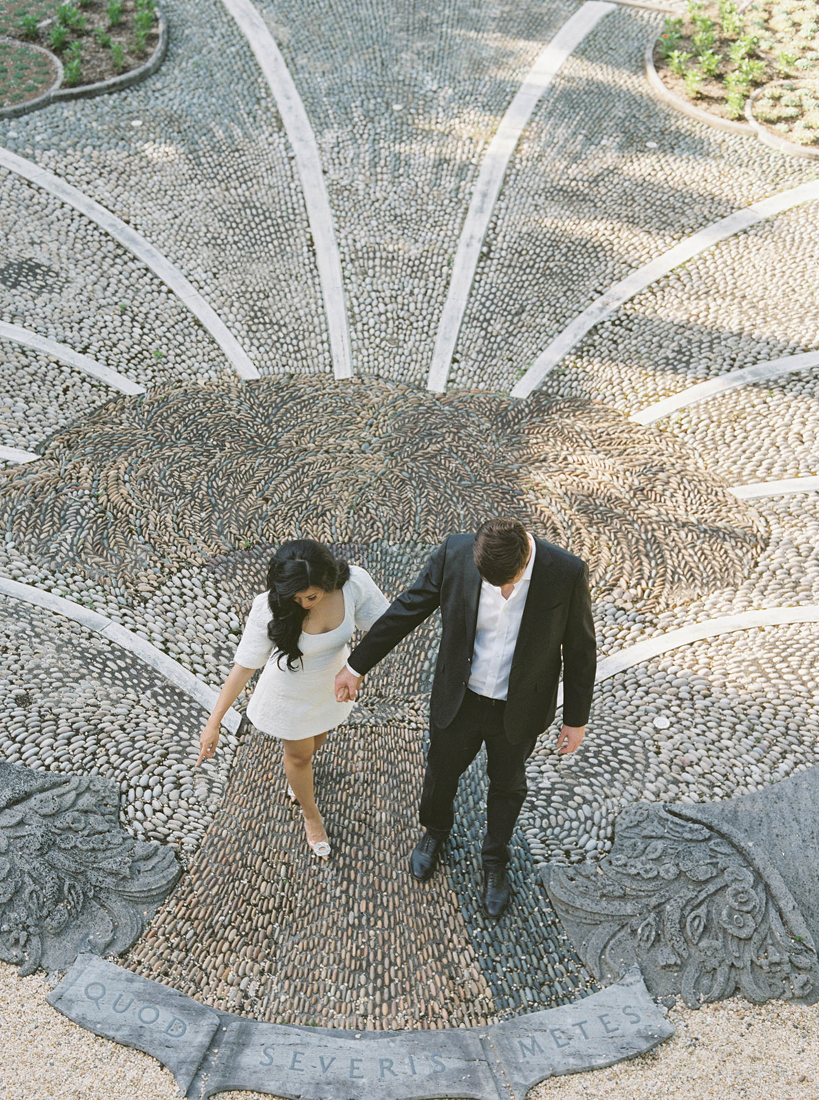 A couple poses for their engagement session in a garden.