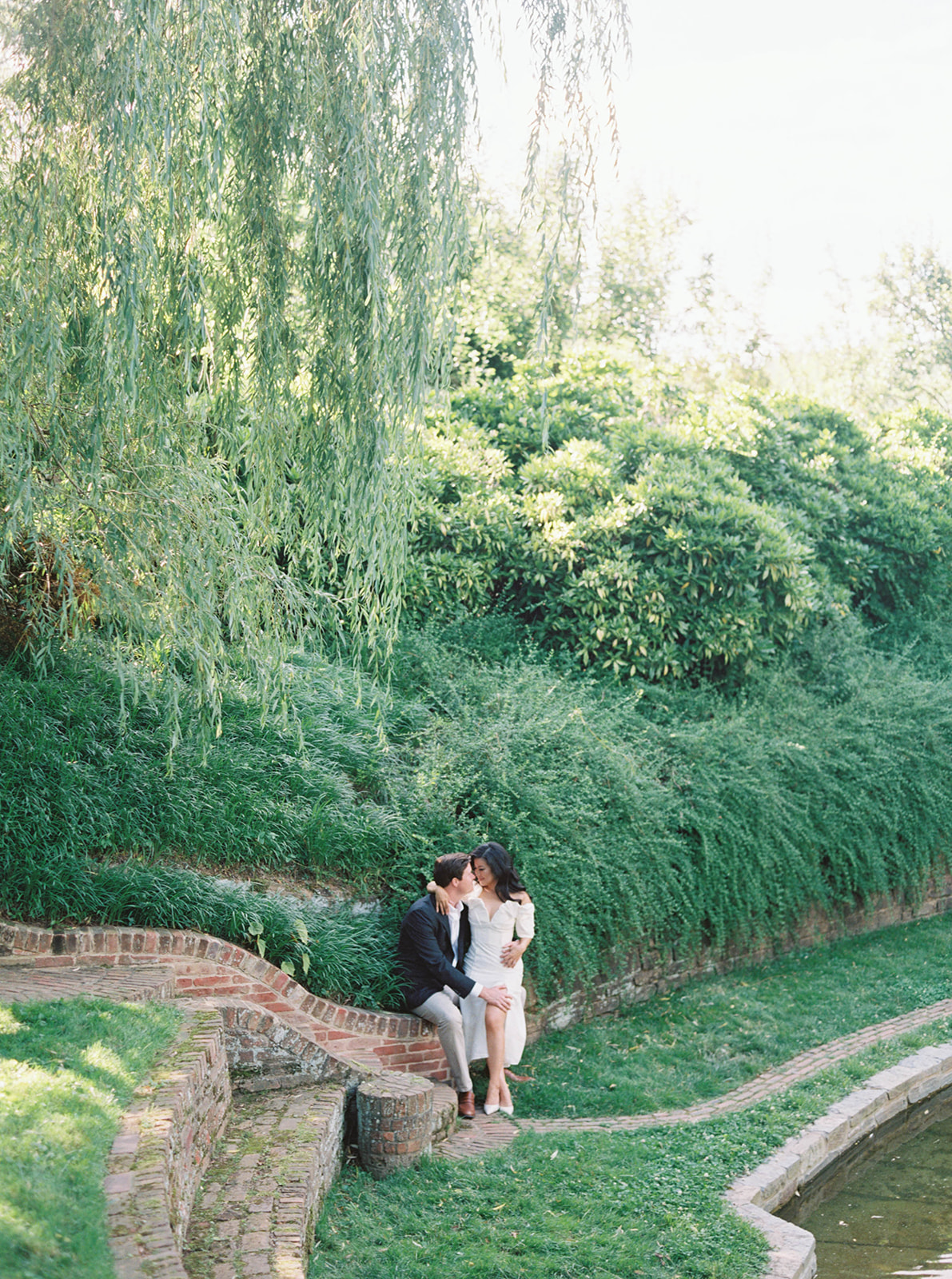 A couple poses for their engagement session in a garden.