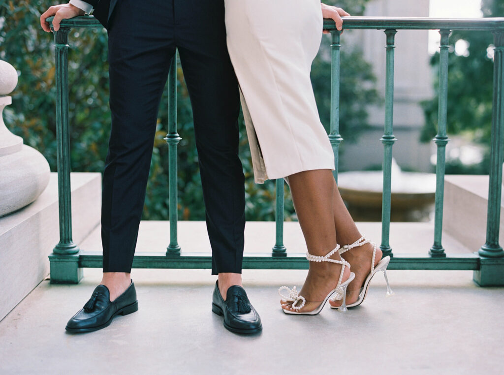 Engagement photos of a couple outside at the National Gallery of Art Museum in Washington, DC. Woman is wearing heels and man is wearing loafers.
