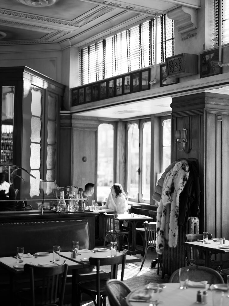 Couple sitting together and talking in a black and white photo at a cafe.