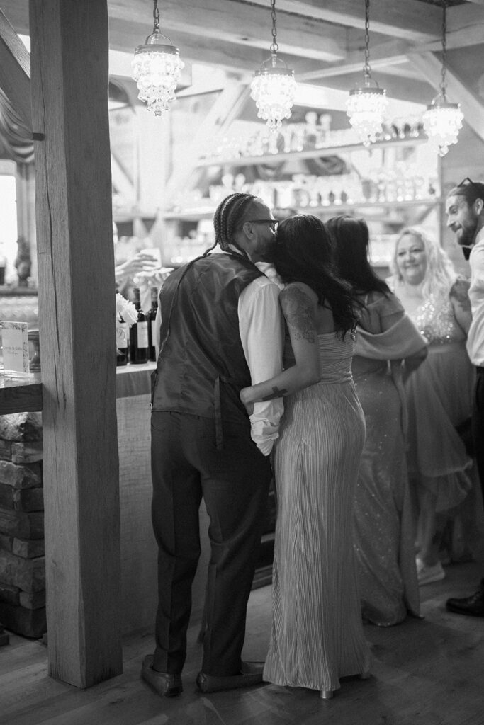 Black and white photo of guests at bar during evening wedding reception