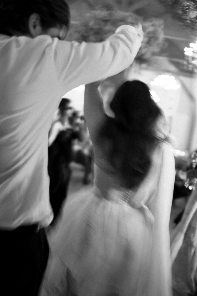 Black and white motion blur of bride and groom dancing at reception