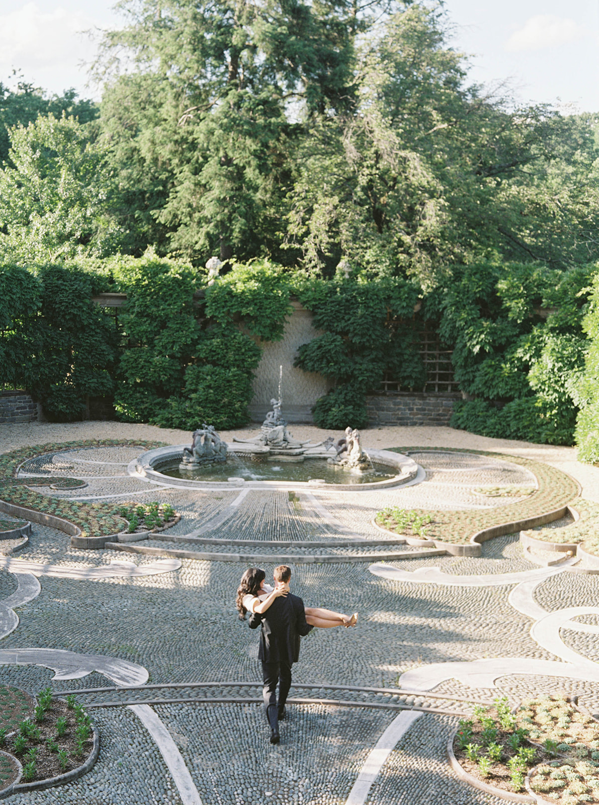 A couple poses for their engagement session in a garden.