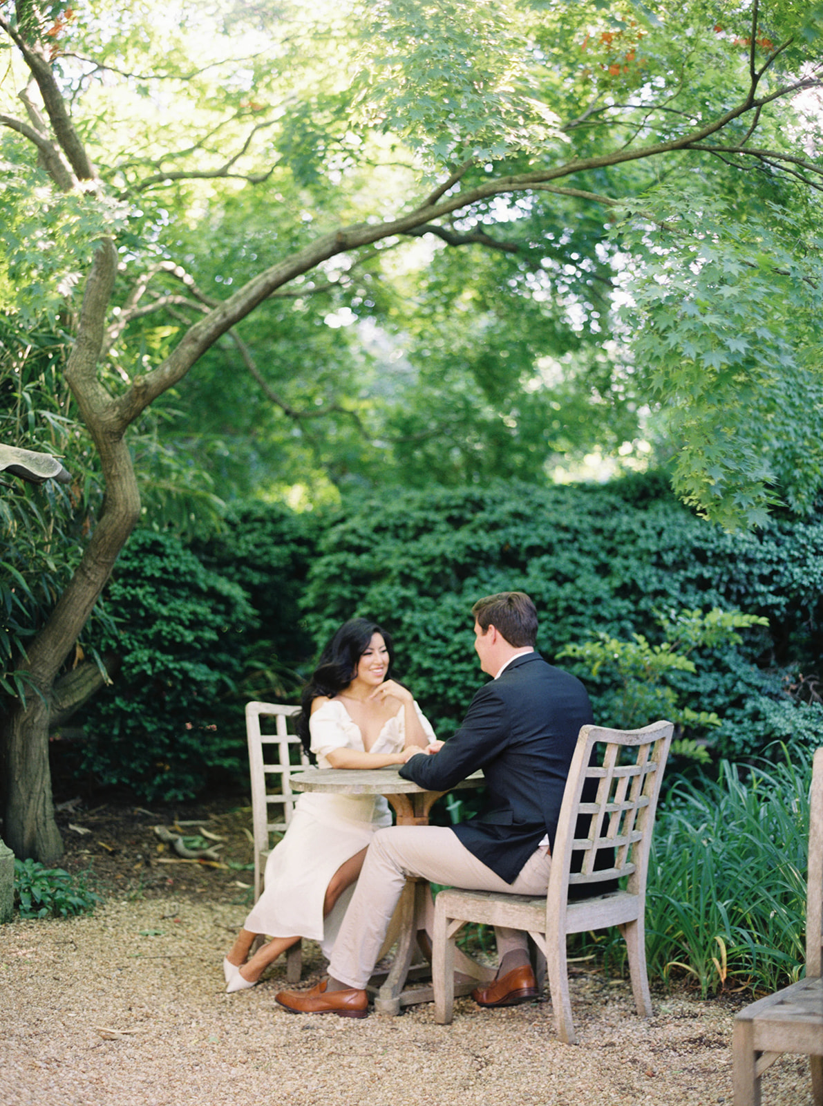 A couple poses for their engagement session in a garden.