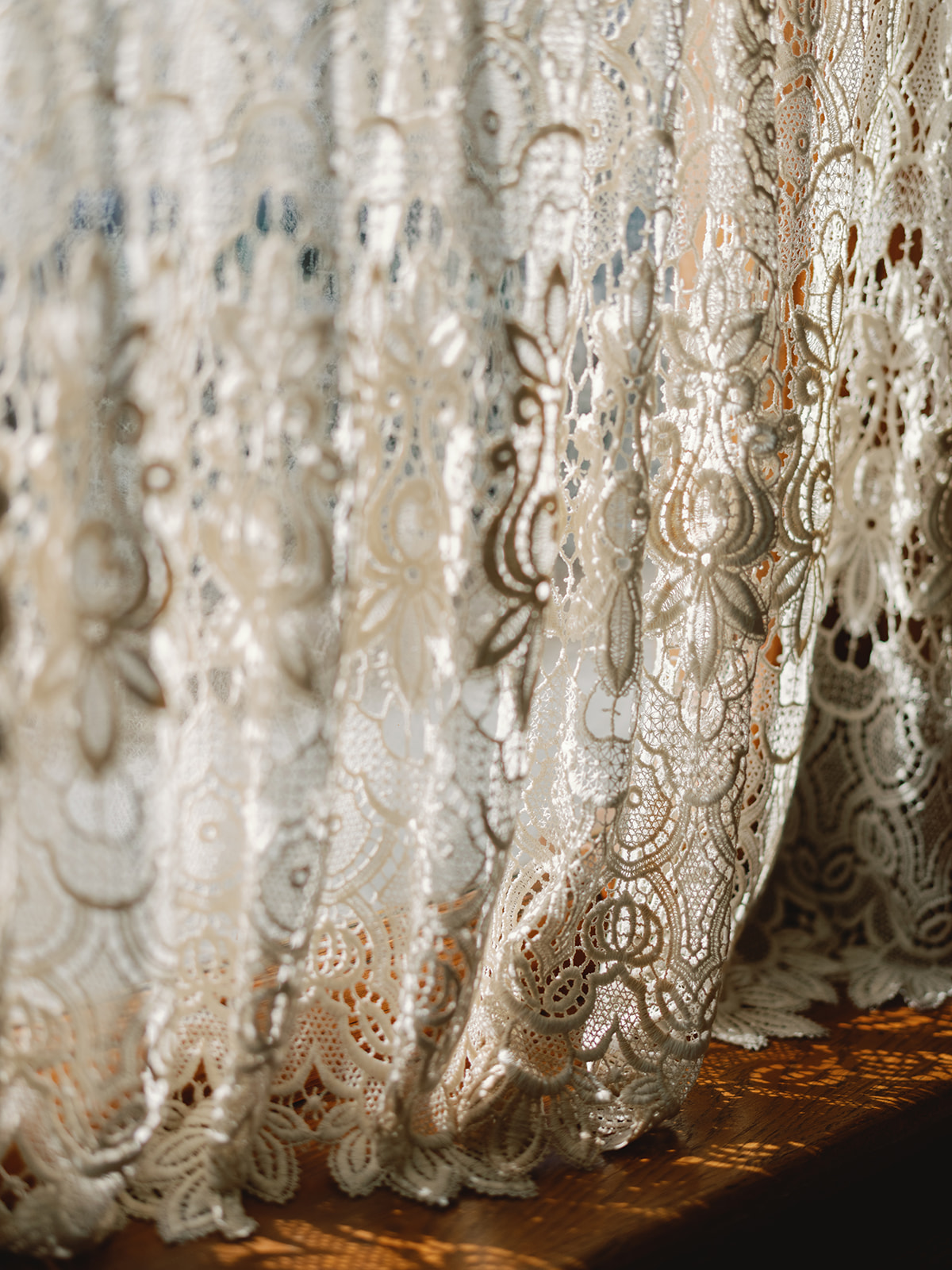 Lace white curtain with light and shadows on a window sill
