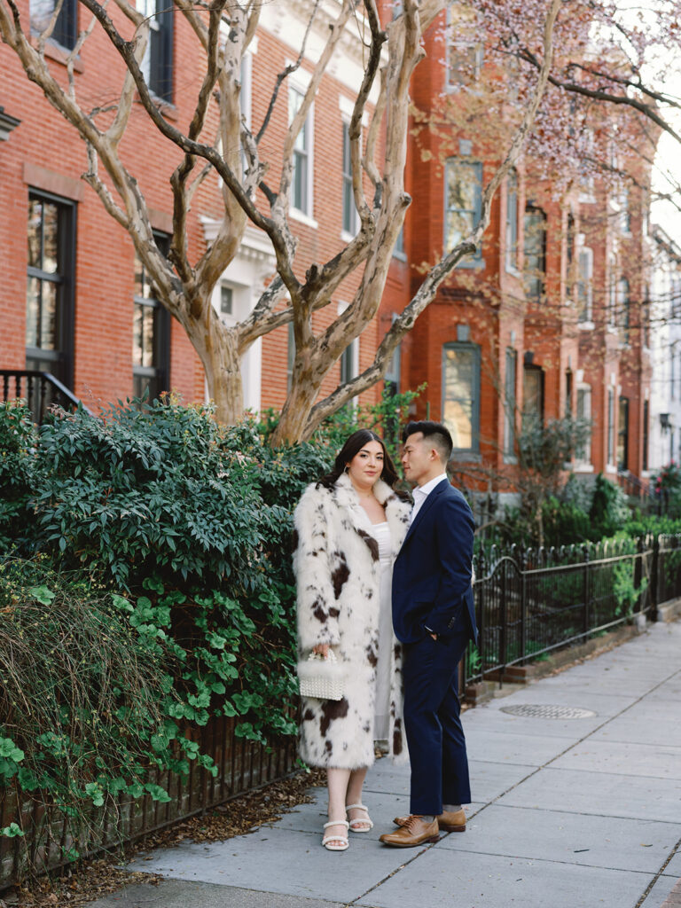 Couple standing in front of brick town houses for their engagement photos in Logan Circle in Washington, DC.
